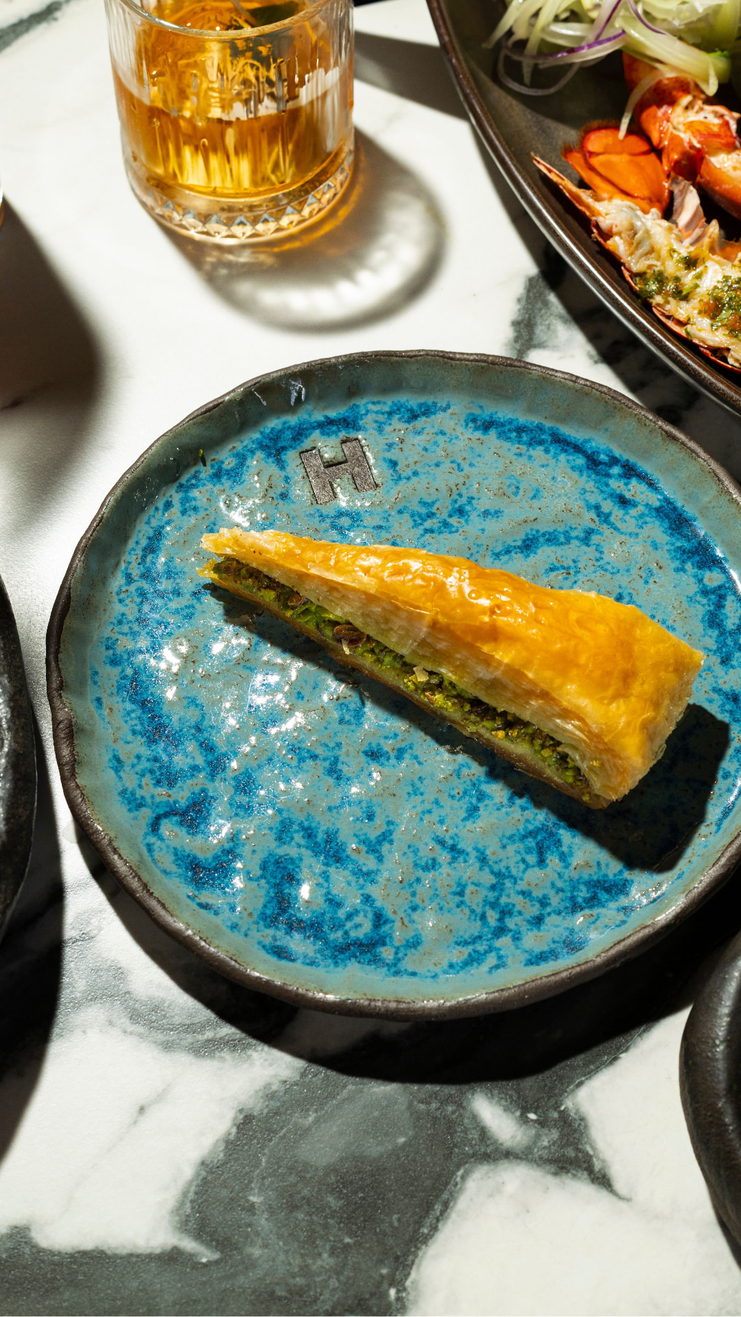 Pistachio baklava on a blue ceramic plate