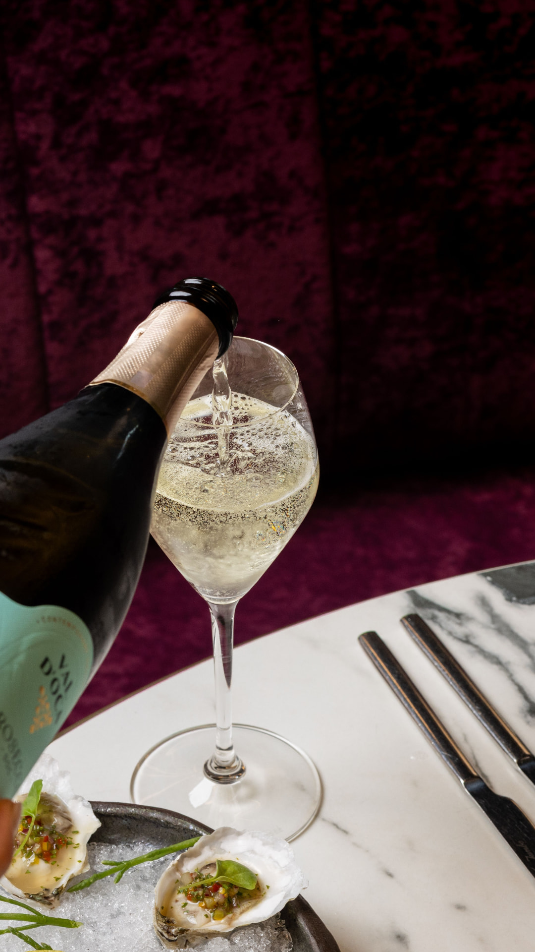 Sparkling wine poured beside oysters